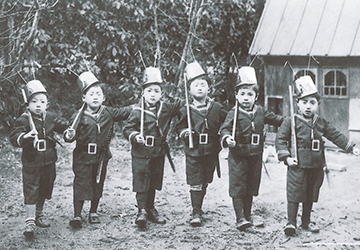 幼稚園の遊戯「蟻の演習」（昭和11年）。園児らも兵隊姿に